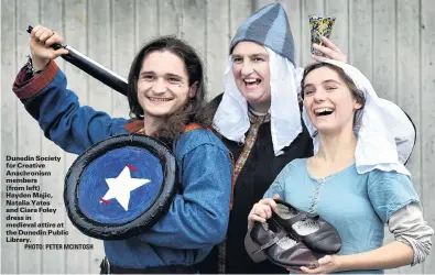  ?? PHOTO: PETER MCINTOSH ?? Dunedin Society for Creative Anachronis­m members
(from left)
Hayden Majic, Natalia Yates and Ciara Foley dress in medieval attire at the Dunedin Public Library.