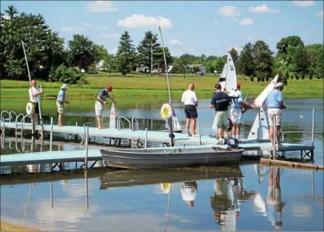  ?? COURTESY OF STEVE SEARS ?? Some members of the Western Reserve Model Yacht Club use body English to pilot their boats, although their hand-held radio controls do the job.