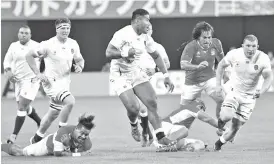  ??  ?? England’s centre Manu Tuilagi (C) runs with the ball during the Japan 2019 Rugby World Cup Pool C match between England and Tonga. - AFP photo