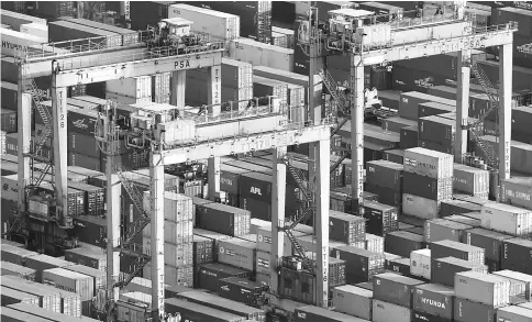  ??  ?? Stacked containers sit among gantry cranes at Tanjong Pagar Container Terminal, operated by PSA Internatio­nal at the Port of Singapore on Sept 15, 2016. — WP-Bloomberg