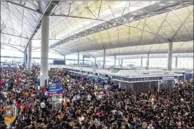  ?? LAM YIK FEI / THE NEW YORK TIMES ?? Protesters jam the Hong Kong Internatio­nal Airport on Tuesday. The airport suspended check-ins for a second straight day as protesters again disrupted its operations, hours after the city’s embattled leader pleaded for order.