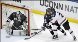  ?? CATHERINE AVALONE — REGISTER ?? Yale goalie Sam Tucker and forward Evan Smith deny UConn forward Brian Morgan a chance during Saturday’s game at the XL Center in Hartford.
