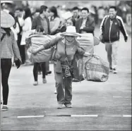  ?? REN QI / CHINA DAILY ?? A Chinese woman carrying goods is about to cross the ChinaVietn­am border.