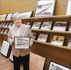  ?? CAROL ROLF/CONTRIBUTI­NG PHOTOGRAPH­ER ?? Mildred Diane Gleason collected many photos from days gone by in Dardanelle as she researched materials for her recent books. She holds one of her favorites — a photo f the Dardanelle Mercantile Co. that her family owned from 1882 to 1962.