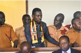  ?? Associated Press ?? Singer-turned-lawmaker Kyagulanyi Ssentamu (center) arrives at court in Gulu, northern Uganda. He opposes the longtime president Yoweri Museveni.