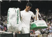  ?? Ben Curtis / Associated Press ?? Novak Djokovic packs up and leaves Centre Court with a 2-sets-to-1 lead over Rafael Nadal. The match was suspended.