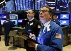  ?? Richard Drew/Associated Press ?? Traders Sal Suarino, right, and Andrew Silverman work on the floor of the New York Stock Exchange on Tuesday morning.