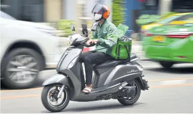  ?? AFP ?? A Grab Food delivery driver is seen in the capital on May 4.