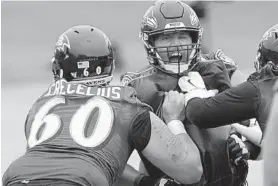  ?? KARL MERTON FERRON/BALTIMORE SUN ?? Ravens guard/tackle James Hurst gets hit by guard/tackle Randin Crecelius (60) during the final day of minicamp at the Ravens’ training facility on June 13.