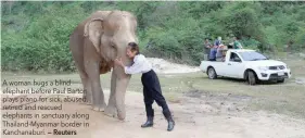  ?? — Reuters ?? A woman hugs a blind elephant before Paul Barton plays piano for sick, abused, retired and rescued elephants in sanctuary along Thailand-myanmar border in Kanchanabu­ri.