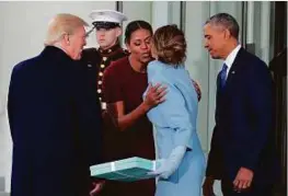  ?? AP ?? Michelle Obama, flanked by Barack Obama and Donald Trump, greets Melania Trump at the White House in Washington DC.