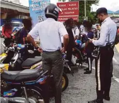  ?? ?? SEBANYAK 29 saman dikeluarka­n polis selepas melakukan pemeriksaa­n terhadap 25 motosikal ditunggang pelajar sekolah.