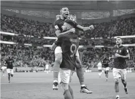  ?? Ebrahim Noroozi/associated Press ?? France's Olivier Giroud celebrates with Kylian Mbappé, after scoring the opening goal during Sunday's World Cup game against Poland in Doha, Qatar.