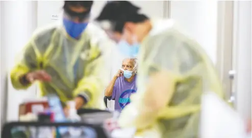  ?? CARLOS OSORIO / REUTERS FILES ?? A senior waits her turn as nurses in Toronto administer the Moderna vaccine on March 25. Studies show that the
elderly and infirm don’t get the full benefits of the second dose if it is delayed, Diane Francis writes.