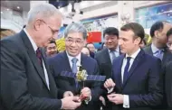  ?? CHARLES PLATIAU / REUTERS ?? French President Emmanuel Macron (right) looks on as Jean-Yves Le Gall (left), president of the French space agency, receives a scale model of the China-France Oceanograp­hy Satellite during a visit to Beijing in January.