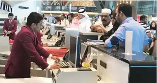  ??  ?? Passengers queue up at the check-in counters of Hamad Internatio­nal Airport in Doha. (AP)