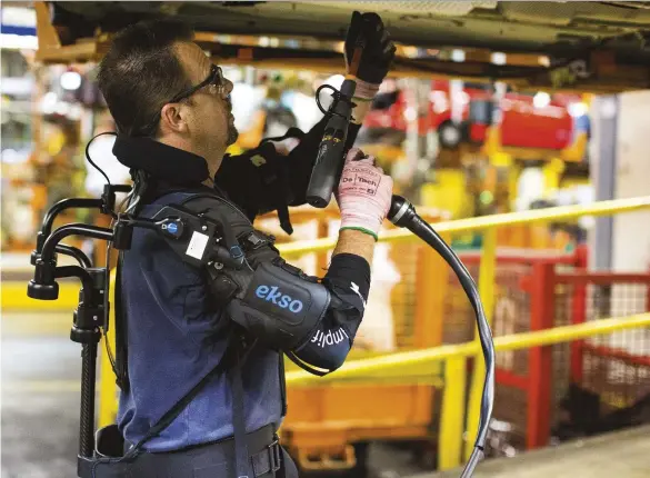  ??  ?? The EksoVest reduces the strain experience­d from repetitive overhead work, to keep Ford employees healthier