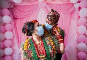  ?? — dpa ?? a bride and groom wearing face masks as a precaution while posing for a photo after their marriage ceremony marked by strict physical distancing measures.