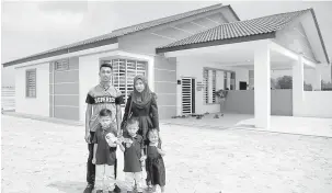  ?? — Gambar Bernama ?? GEMBIRA: Penduduk tempatan Maiyenri Farid,26, bersama isteri Nur Fatin Abdul Aziz, 25, dan tiga anak bergambar di hadapan rumah yang bakal diterima selepas membeli Perumahan Rakyat 1Malaysia (PR1MA) Pahang di Kampung Sungai Baging, dekat Kuantan, semalam.