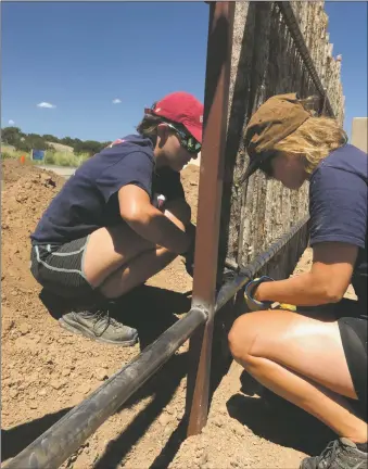  ?? PHOTOS BY PAUL WEIDEMAN ?? Sarah Feyers and Lotte Ludekens with Bike & Build working on a coyote fence in Oshara on June 24. Below, a recently completed Habitat house on Willow Back Road.