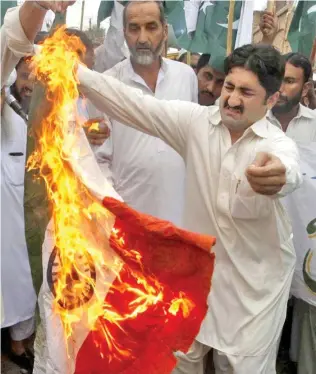  ??  ?? Pakistani protesters burn a representa­tion of an Indian flag.