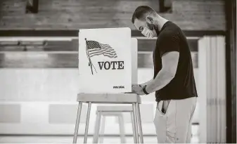  ?? Marc Piscotty / Getty Images ?? First-time voter Daylon Stutz, 23, votes Nov. 3 in Golden, Colo. A ballot measure to reduce the state’s flat income tax from 4.63 to 4.55 percent passed by a margin of 57.7 to 42.7 percent.