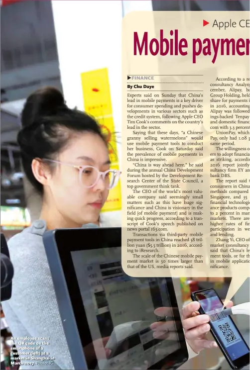  ?? Photo: IC ?? An employee scans the QR code on the smartphone of a customer ( left) at a market in Shanghai in March 2017.