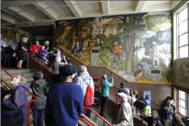  ?? PHOTOS BY ERIC RISBERG — THE ASSOCIATED PRESS FILE ?? People fill the main entryway of George Washington High School in San Francisco to view the controvers­ial 13-panel, 1,600-square foot mural the “Life of Washington” during an open house for the public.