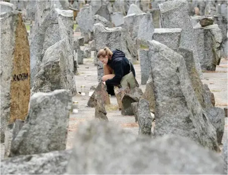  ?? Foto: AFP/Janek Skarzynski ?? Eine Besucherin entzündet in der Gedenkstät­te Treblinka eine Kerze.