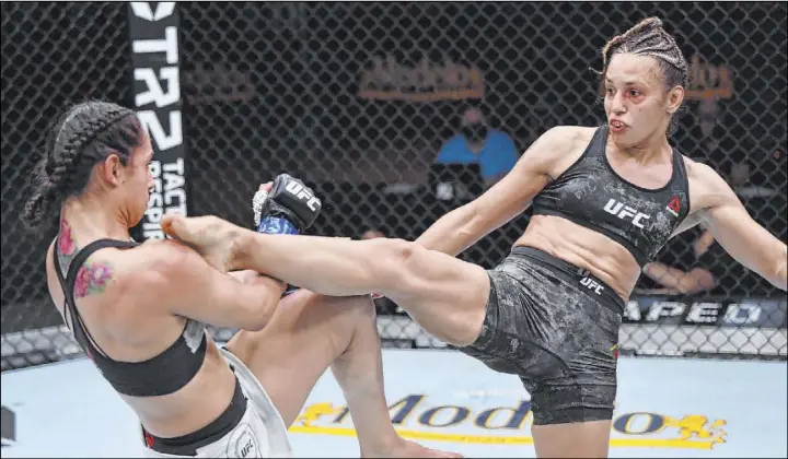  ?? Jeff Bottari Zuffa LLC ?? Antonina Shevchenko, right, kicks Ariane Lipski on the way to knockout in the women’s flyweight bout at UFC 255. Shevchenko and her sister Valentina got wins on Saturday.
