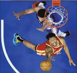  ?? Matt Slocum Associated Press ?? ATLANTA’S Solomon Hill, bottom, shoots under pressure from Philadelph­ia’s Joel Embiid during the second half of Game 5 of their second-round series.