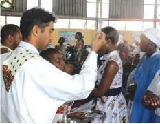  ??  ?? Parish Priest for St Peter Claver in Mbare, Father Fernandez SJ administer the sacrament of Holy Eucharist during a service