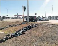  ??  ?? GOING NOWHERE: The arrested suspects lie on the ground after their vehicle was pulled off the road