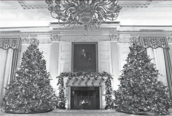  ?? EVAN VUCCI/AP ?? The State Dining Room of the White House is decorated for the holiday season during a press preview of the White House holiday decoration­s.