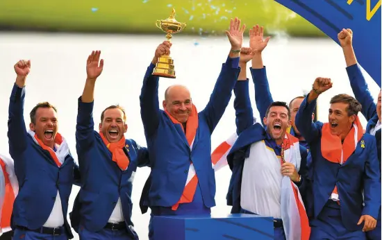  ?? PHOTO: RAMSEY CARDY ?? Rory McIlroy celebrates with team-mates as Europe captain Thomas Bjørn lifts the Ryder Cup after a crushing victory over Team USA at Le Golf National in Paris.