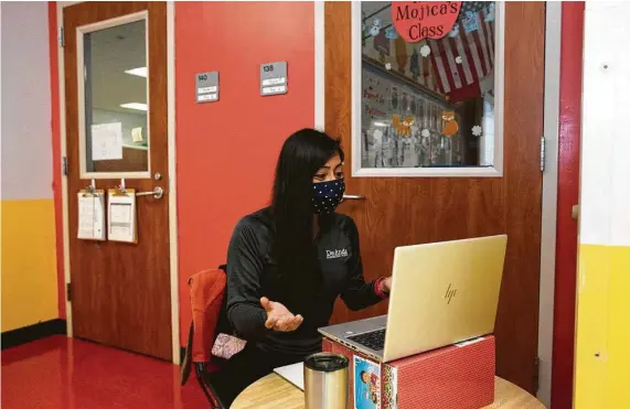  ?? Yi-Chin Lee / Staff photograph­er ?? Mayra Mojica, a pre-K teacher at James DeAnda Elementary School, teaches a virtual class in the hallway so she would not distract her in-person students.