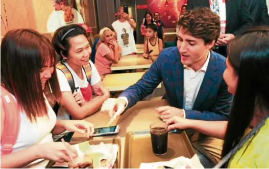  ?? –PHOTOS FROMJOLLIB­EE ?? Canadian Prime Minister Justin Trudeau shares fries with guests.