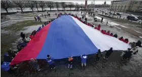  ?? DMITRI LOVETSKY — THE ASSOCIATED PRESS ?? Young people unfurl a giant Russian flag during an action to mark the ninth anniversar­y of