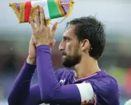  ??  ?? Davide Astori con il gagliardet­to della Fiorentina Nella foto grande i messaggi e le sciarpe fuori dai cancelli del Franchi