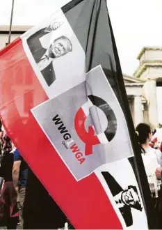  ?? Foto: Kay Nietfeld, dpa ?? Auf einer Corona‰Demo in Berlin war diese Fahne zu sehen: Neben Bildern von US‰ Präsident Donald Trump ist der Buchstabe „Q“für QAnon sowie der Slogan dieser Verschwöru­ngsbewegun­g – „WWG1WGA“– zu erkennen.