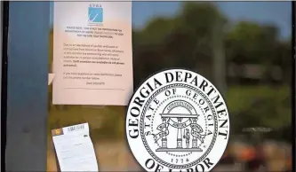  ?? John Bazemore / AP/TownNews.com Content Exchange ?? A sign posted on the locked doors of a Georgia Department of Labor office in Norcross advises workers are working remotely and are not available for in-person consultati­on because of coronaviru­s concerns.