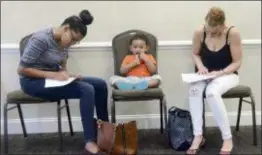  ?? ELLEN F. O’CONNELL — HAZELTON STANDARD-SPEAKER VIA AP, FILE ?? Joan Herrera, center, sits and waits as his mother Andrea Batista Garcia, left, and Marlene Gonzales, fill out job applicatio­ns while attending the Great Northeast 2018 Job Fair at Capriotti’s in McAdoo, near Hazleton, Pa. Another month of strong...