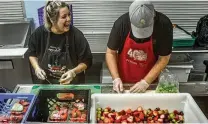  ?? JIM NOELKER / STAFF ?? House of Bread volunteers Alli Hachey (left) and Luke Bohardt, create a fruit medley at the House of Bread on Orth Avenue in Dayton.