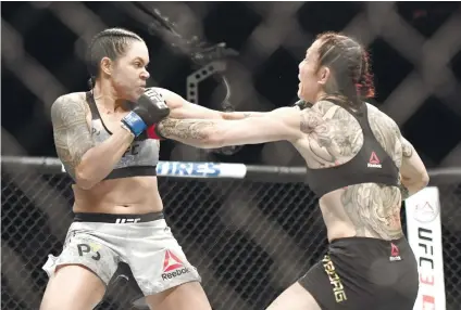  ?? AP FOTO ?? NEW QUEEN. Amanda Nunes (left) lands a left hook on Cris Justino’s (right) face. It took only 51 seconds for Nunes to stop the “Cyborg” and end the latter’s 13-year unbeaten run.