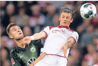  ?? FOTO: M. BECKER/DPA ?? Augen zu und durch: Düsseldorf­s Dawid Kownacki (re.) und Wolfsburgs Robin Knoche kämpfen um den Ball.