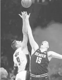  ?? STEPHEN M. DOWELL/ORLANDO SENTINEL ?? Magic center Nikola Vucevic (9) and Nuggets center Nikola Jokic vie for the opening tip during Wednesday’s game at Amway Center.