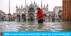  ??  ?? VENICE: A woman crosses the flooded St Mark’s Square near St Mark’s Basilica after an exceptiona­l overnight “Alta Acqua” high tide water level early yesterday. — AFP
