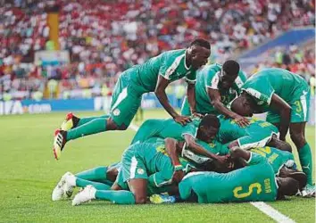  ?? AP ?? Senegal’s Mbaye Niang celebrates with his teammates after scoring his side’s second goal during the Group H game against Poland in the Otkritie Arena in Moscow yesterday.