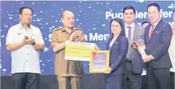  ?? — Bernama photo ?? Chief Minister Datuk Seri Hajiji Noor (second left) presenting State Management and Profession­al Employee Award to the headmistre­ss of SM St Michael, Penampang, Jennifer Asing, during the state-level Labour Day Tripartite 2024 celebratio­n at the Internatio­nal Convention Centre on Tuesday. On the left is Abdul Rahman Mohamad.