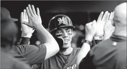  ?? DYLAN BUELL/GETTY ?? The Brewers celebrate after a solo shot by Christian Yelich ups his home run total to 34.